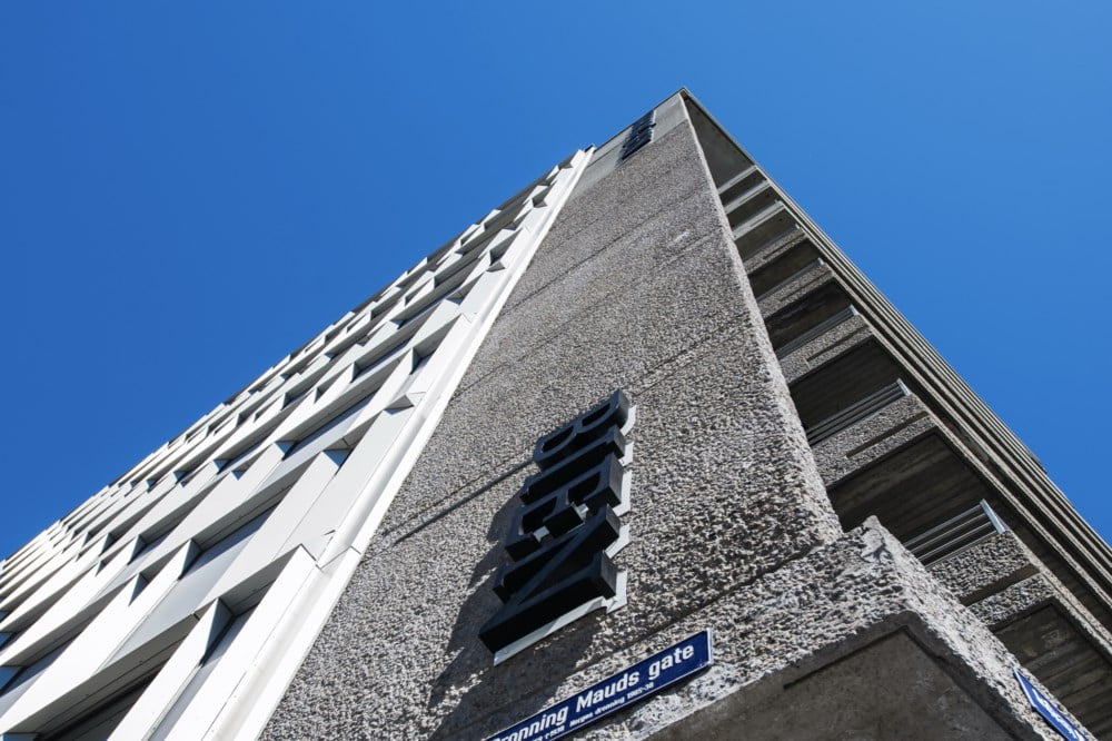 Høy bygning sett nedenifra med blå himmel.