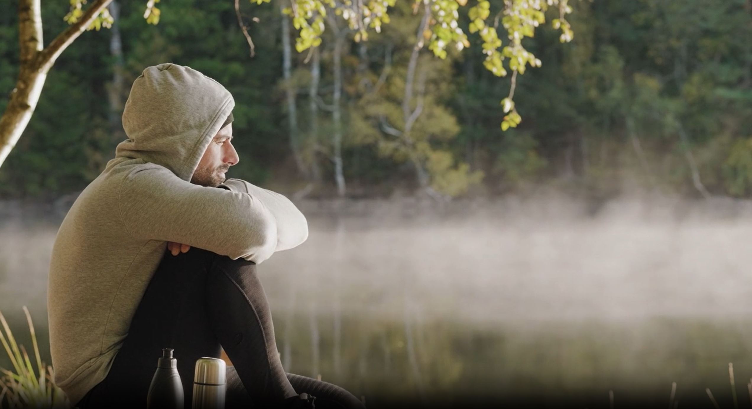 Ein mann ser ut over eit tåkebelagt vatn