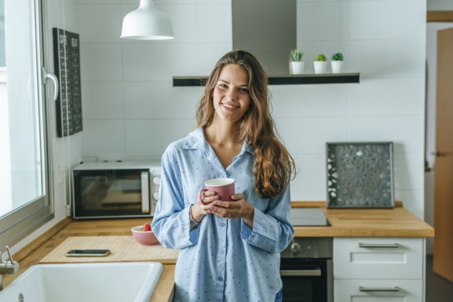 Ung kvinne holder kaffekopp. Artikkelbilde. Foto.